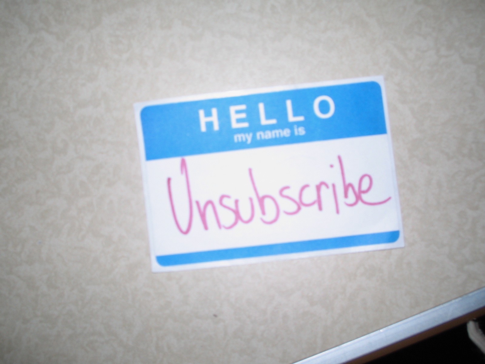Name tag sticker where the handwritten name says Unsubscribe.